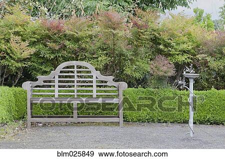 Stock Photo - Drinking fountain and ornamental wooden bench. Fotosearch