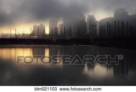 Stock Image - Early morning fog and mist over the waterfront and tall buildings of Vancouver. Fotosearch
