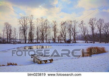 Stock Photo - Frozen pond and snow on the ground in winter. Fotosearch