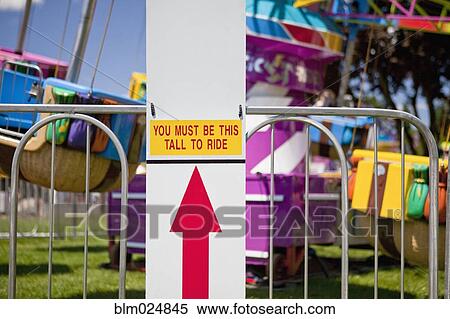 Stock Photography - Height Requirement Sign In Front Of Amusement Park Ride. Fotosearch