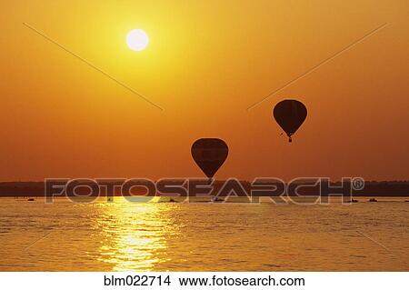Hot Air Balloons Over Water at Sunset View Large Photo Image Picture - Hot Air Balloons Over Water at Sunset. Fotosearch