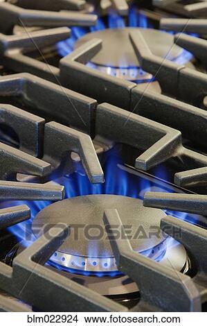 Picture - Ignited Gas Burning on Commercial Stove. Fotosearch