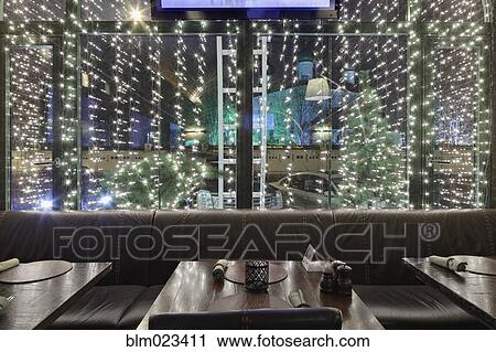 Stock Image - Illuminated restaurant window. Fotosearch