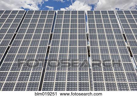 Stock Image - Large Solar Panel against cloudy sky. Fotosearch