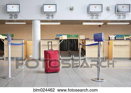 Stock Image - Luggage at an Airline Check-In Counter. Fotosearch