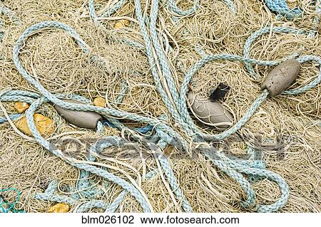 Pile of fishing nets, floats and blue rope on the quayside at Dungeness View Large Photo Image Stock Image - Pile of fishing nets, floats and blue rope on the quayside at Dungeness. Fotosearch