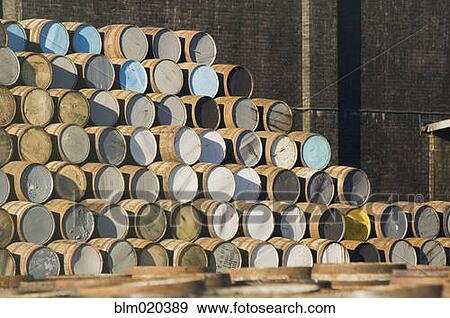Stock Photo - Pile of whisky barrels outside a warehouse. Fotosearch