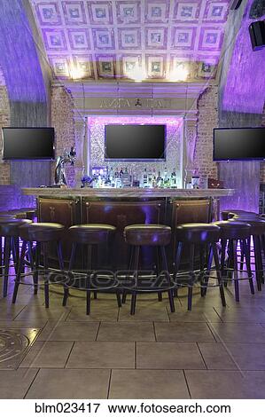 Round bar stand against three TV screens on brick wall lighted in purple View Large Photo Image Stock Photo - Round bar stand against three TV screens on brick wall lighted in purple. Fotosearch