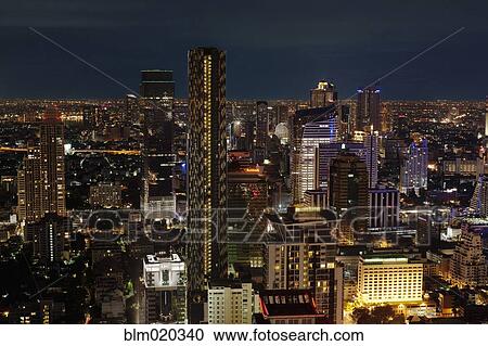Stock Image - skyscrapers illuminated against the evening sky. Fotosearch