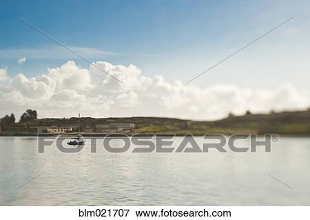 Stock Photo - Small Sailboat Anchored in Bay. Fotosearch
