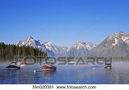 Steam rises from Jackson Lake with the Grand Tetons as background in early morning View Large Photo Image Stock Image - Steam rises from Jackson Lake with the Grand Tetons as background in early morning. Fotosearch