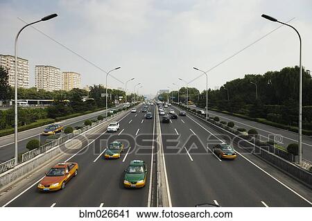 Stock Image - Taxis and other cars drive the second ring road around Beijing. Fotosearch