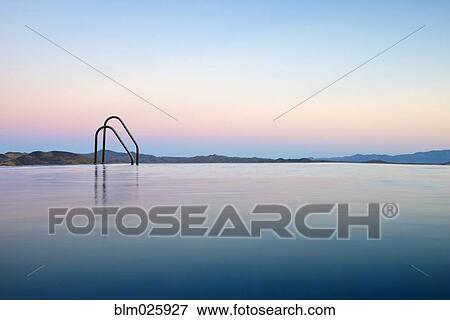 The colors of the setting sun reflecting in an infinity pool overlooking the Andalucian mountains View Large Photo Image Stock Photo - The colors of the setting sun reflecting in an infinity pool overlooking the Andalucian mountains. Fotosearch