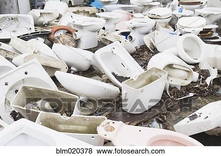 Stock Photo - Toilets and basins stacked in a scrapyard. Fotosearch
