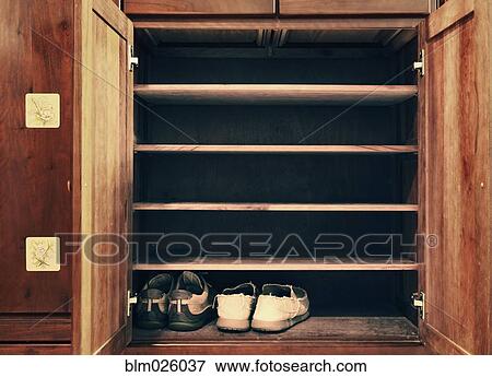 Two pairs of shoes in an old wooden cabinet View Large Photo Image Stock Photo - Two pairs of shoes in an old wooden cabinet. Fotosearch