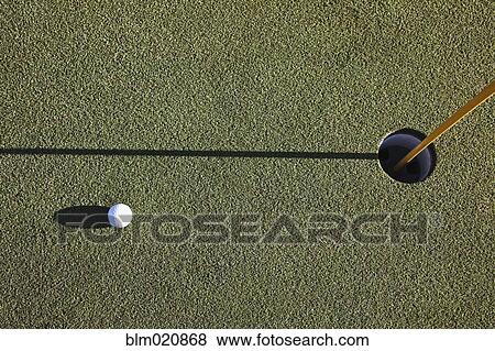 Stock Photo - White Golf Ball Near the Cup. Fotosearch