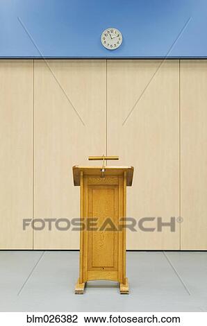 Wooden lectern and clock in the main hall of a modern secondary school View Large Photo Image Stock Image - Wooden lectern and clock in the main hall of a modern secondary school. Fotosearch