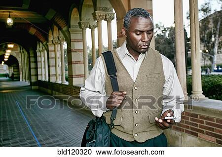 Stock Image - African American professor smiling on campus. Fotosearch