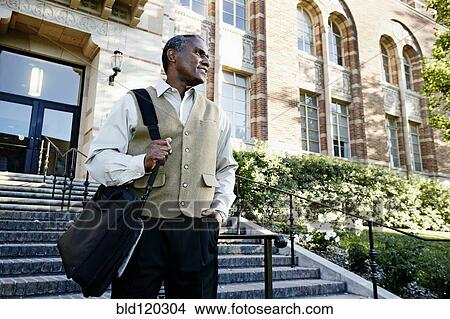 Picture - African American professor walking on campus. Fotosearch