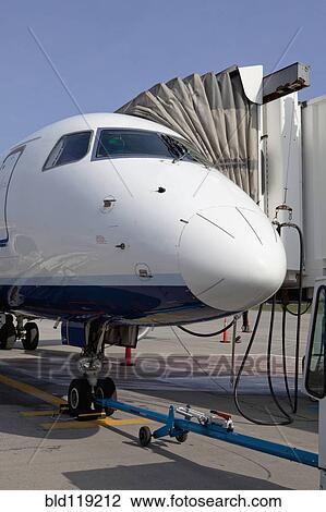 Stock Image - Airplane and boarding apparatus on runway. Fotosearch