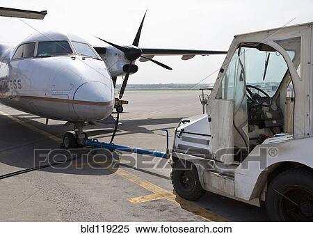 Stock Photography - Airplane and cart parked on runway. Fotosearch
