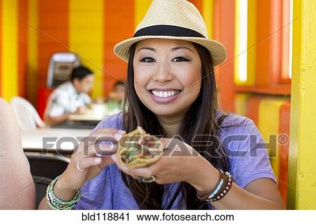 Asian woman eating in restaurant View Large Photo Image Stock Image - Asian woman eating in restaurant. Fotosearch