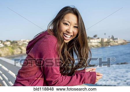 Asian woman smiling on bridge View Large Photo Image Stock Photo - Asian woman smiling on bridge. Fotosearch