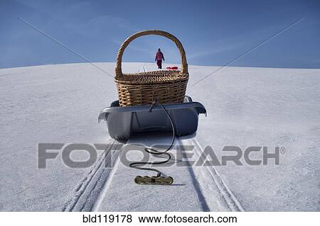 Stock Photo - Basket on wagon making tire tracks in snowy landscape. Fotosearch