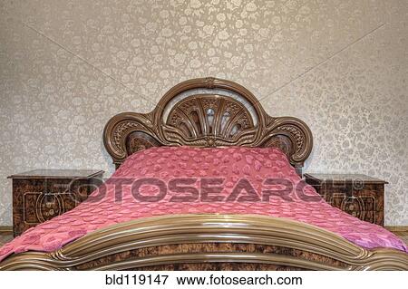 Bed with carved wooden headboard View Large Photo Image Stock Photo - Bed with carved wooden headboard. Fotosearch