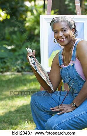 Stock Photo - Black artist painting outdoors. Fotosearch