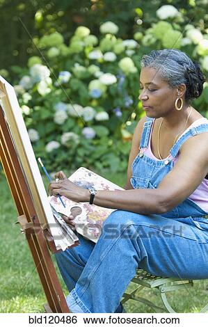 Stock Photograph - Black artist painting outdoors. Fotosearch