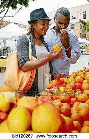 Stock Photo - Black couple shopping at outdoor market. Fotosearch