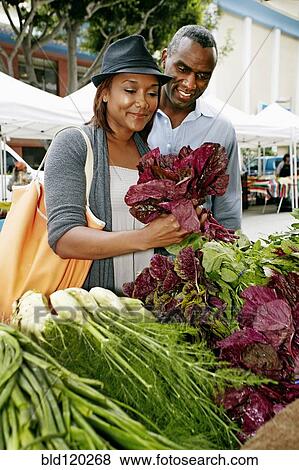 Stock Photo - Black couple shopping at outdoor market. Fotosearch