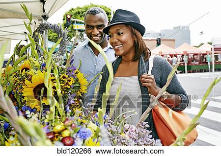 Stock Photograph - Black couple shopping at outdoor market. Fotosearch