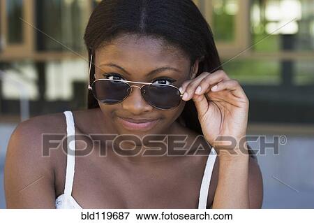 Stock Photo - Black girl wearing sunglasses outdoors. Fotosearch