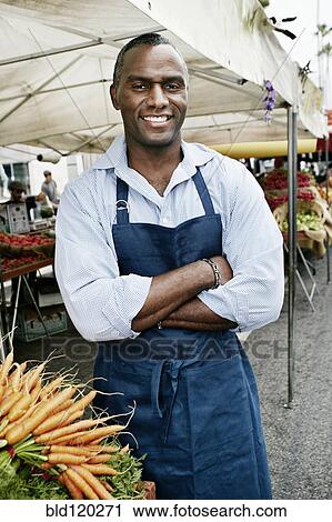 Stock Image - Black man working at outdoor market. Fotosearch