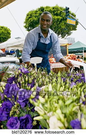 Stock Photograph - Black man working at outdoor market. Fotosearch