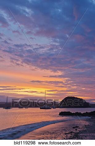 Stock Photo - Boats sailing in bay at sunrise, Bay of Islands, Paihia, New Zealand. Fotosearch