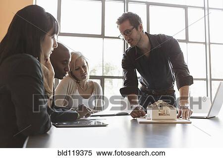 Business people examining model in meeting View Large Photo Image Stock Photography - Business people examining model in meeting. Fotosearch