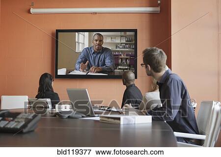 Stock Photo - Business people having teleconference in meeting. Fotosearch