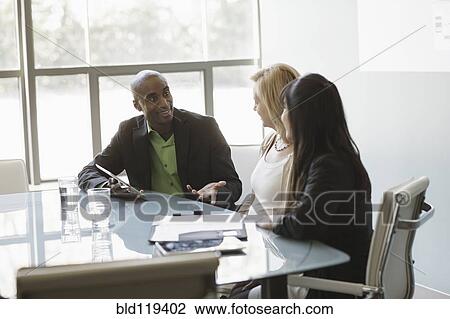 Stock Image - Business people talking in meeting. Fotosearch