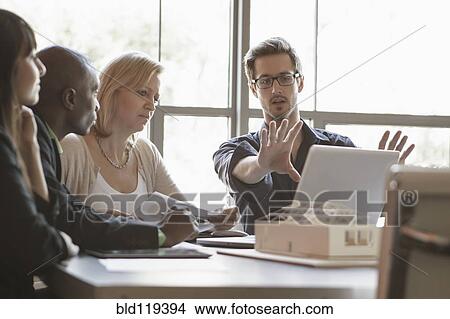 Picture - Business people using laptop in meeting. Fotosearch