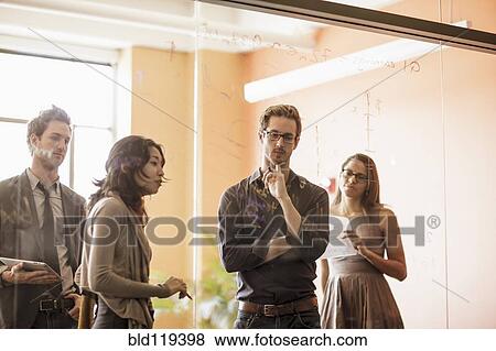 Stock Photo - Business people writing on glass wall. Fotosearch