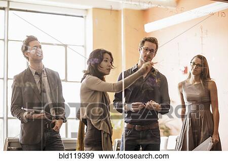 Business people writing on glass wall View Large Photo Image Stock Photo - Business people writing on glass wall. Fotosearch