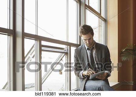 Stock Image - Businessman using tablet computer. Fotosearch
