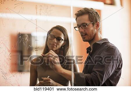 Businessman writing on glass wall View Large Photo Image Stock Image - Businessman writing on glass wall. Fotosearch