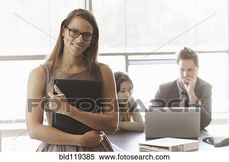 Businesswoman holding folder in meeting View Large Photo Image Stock Photography - Businesswoman holding folder in meeting. Fotosearch