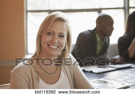 Stock Image - Businesswoman smiling in meeting. Fotosearch
