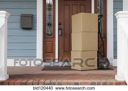 Stock Image - Cardboard boxes on front porch of new house. Fotosearch