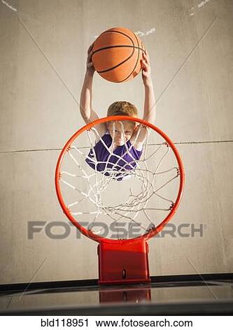 Caucasian boy dunking basketball in hoop View Large Photo Image Stock Image - Caucasian boy dunking basketball in hoop. Fotosearch